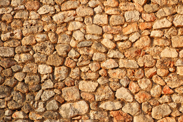 ancient wall made of small bricks in summer at sunset with a clear structure