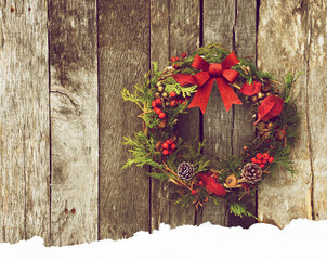 Christmas wreath hanging on a grunge wood wall.