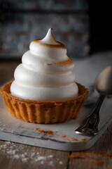 Fototapeta na wymiar Cupcake with white cream on a wooden table