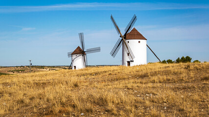 Fototapeta na wymiar Old whitewashed windmills in a field near Mota del Cuervo in Castilla la Mancha, Spain.