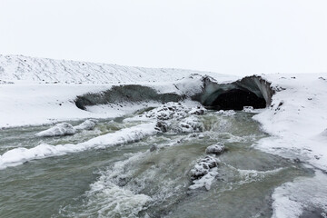 Meltwater flowing from ice cave of glacier in Iceland