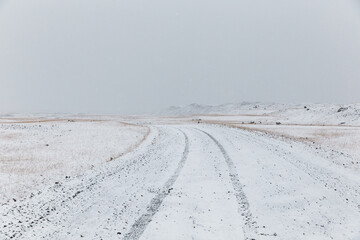 Fototapeta na wymiar Tire tracks on snowy access road in highlands, Iceland
