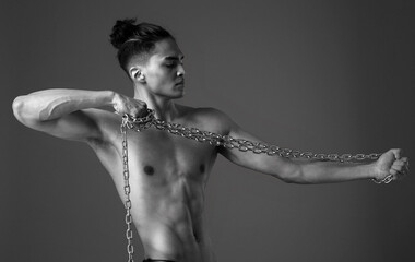 A young man with a naked torso and a chain in his hands