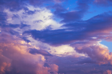 There are dramatic clouds in the dark sky as the sun sets. The sky is dominated by fuchsia, pink.