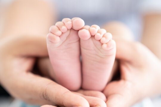 Newborn baby or infant feet in mother hands. Mother takes care for her baby. Mom and Child. Happy family concept