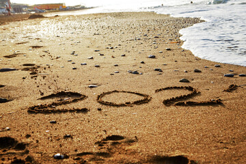 Happy new year 2021 text on the sea beach. Abstract background photo of the upcoming new year 2021