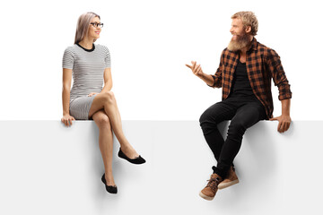 Bearded man with moustaches sitting on a white panel and talking to a young woman