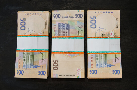 three bundles of hryvnia on a black background. Ukrainian money. 500 hryvnia banknotes. The inscription "National Banu of Ukraine" on the pack.