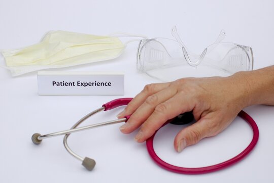 Health Care Concept Demonstrating Patient Experience With Nurse Hand On Stethoscope And Surgical Disposable Mask And Clear Protective Eye Goggles Nearby