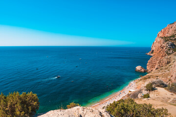 Fototapeta na wymiar Panoramic view of the picturesque beach with white sand and azure water, top view of the beach vacationers, Crimea