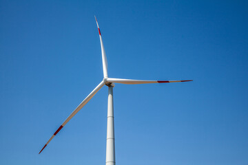Wind turbine for electricity generation, renewable energy on a blue sky background