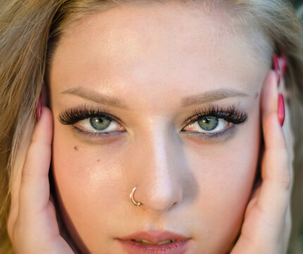 Portrait of a young beautiful girl close-up. Model with pierced nose.