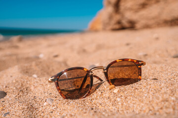 Fototapeta na wymiar Sun glasses lie on a beach near the sea