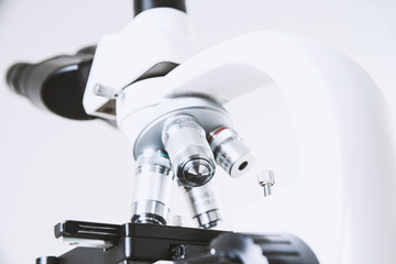 Using a biological microscope. Close-up of the microscope lens. Scientific research concept, using a microscope. Medical examinations, searching for bacteria, diseases, blood tests.