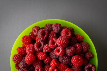 Himbeeren in einer grünen Schale Textfrei grauer Hintergrund