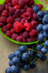 Schale mit Himbeeren und Weintrauben auf Eichen Holz