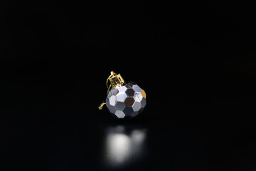 Silver colored New Year tree decoration. Christmas tree bauble sphere on black
