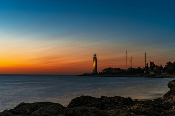 Romantic view of the lighthouse from the cliff at sunset