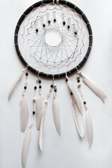 Dream catcher on a white background. Feather toy. Feather ring. Dreamcatcher amulet