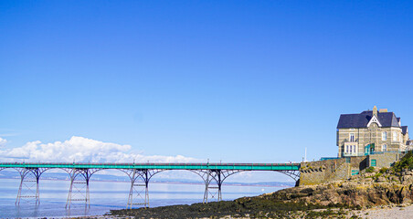 Panoramic photo of Clevedon Pier in somerset showing iron structure against blue sky