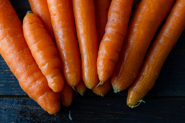 Karotten auf schwarzem Holz im Halbkreis aufgelegt
