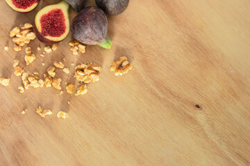 Figs and walnuts from above on a wood table with copy space.