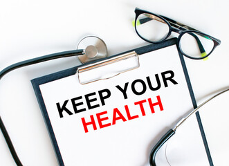 Text Keep Your Health in the folder with the stethoscope and glasses
