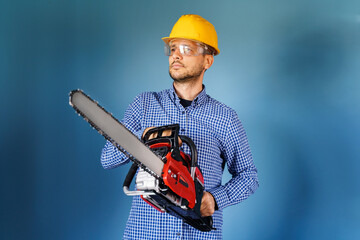 Waist up of adult caucasian man wearing protective helmet and glasses standing in front of the blue...