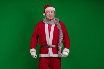 Male actor in a costume of Santa Claus gesturing and posing on a green chroma background