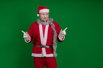 Male actor in a costume of Santa Claus gesturing and posing on a green chroma background