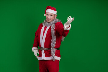 Male actor in a costume of Santa Claus gesturing and posing on a green chroma background