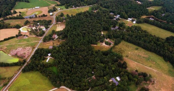 A flight over rural Snow Camp, North Carolina with a poultry operation and poultry sheds show us a unique pond that is half covered by a lime green growth.