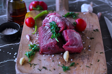raw beef meat on cutting board on black marble background. close up view