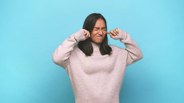 Young mixed race indian woman covering ears with hands