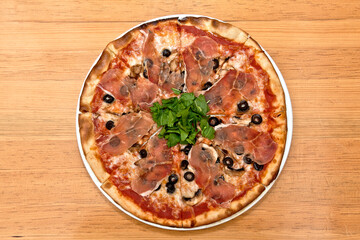 Pizza de Jamón serrano, arúgula, parmesano, y aceitunas negras	