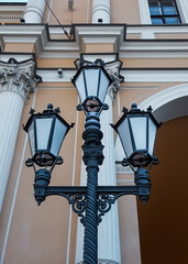 Old vintage black decorative lantern with white glass on pillar against the background of a...