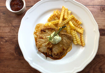In pan seared juicy minute steaks with french fries and rosemary.