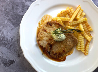 In pan seared juicy minute steaks with french fries and rosemary.