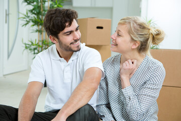 happy young couple sitting between boxes