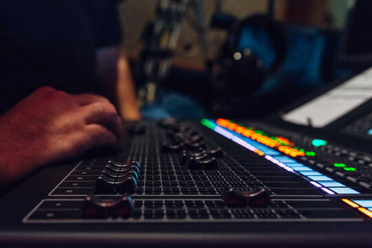 Hands of a sound engineer on a mixing board
