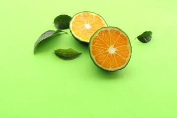 fresh tangerine fruits on green background