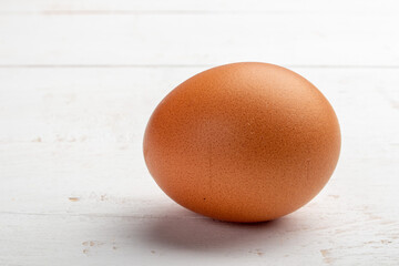 a brown egg on a white wooden background