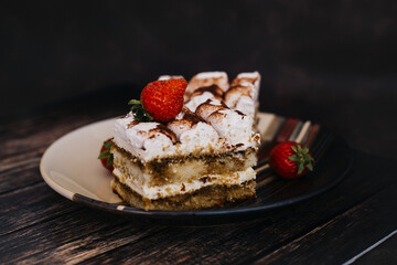 Homemade Tiramisu cake a traditional Italian dessert with strawberries on a dark background