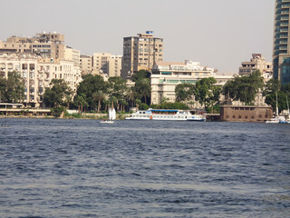 Naklejka premium River Nile bank with a background of modern buildings on a sunny summer day and sailing boats, Cairo, Egypt