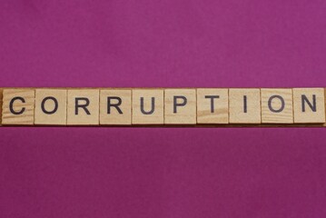 word corruption made from wooden letters lies on a lilac table