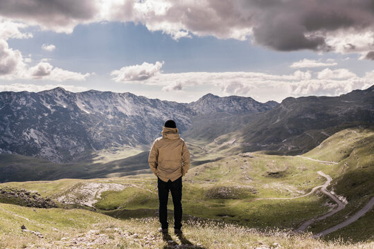 Man looking at green valley and mountains. Durmitor, Montenegro
