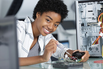 young woman fixing a desktop computer