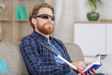 blind man reading braille at home
