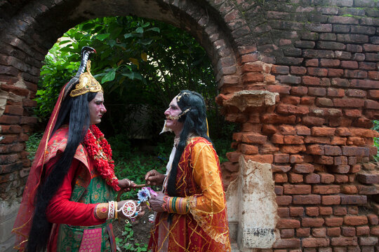Father and son decorating themselves as Hindu God and Goddess and Holding Hands.