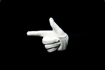 A hand wearing white glove on black background showing a gun symbol